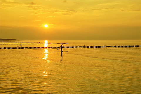 atardecer junto al mar practicando padle